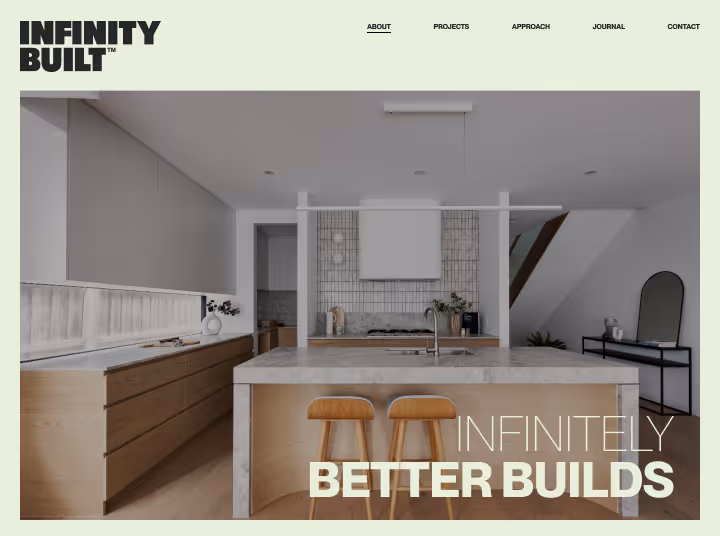 Modern kitchen with wooden cabinets, a marble island with two stools, and minimalist decor under the Infinity Built branding and slogan 'Infinitely Better Builds'.